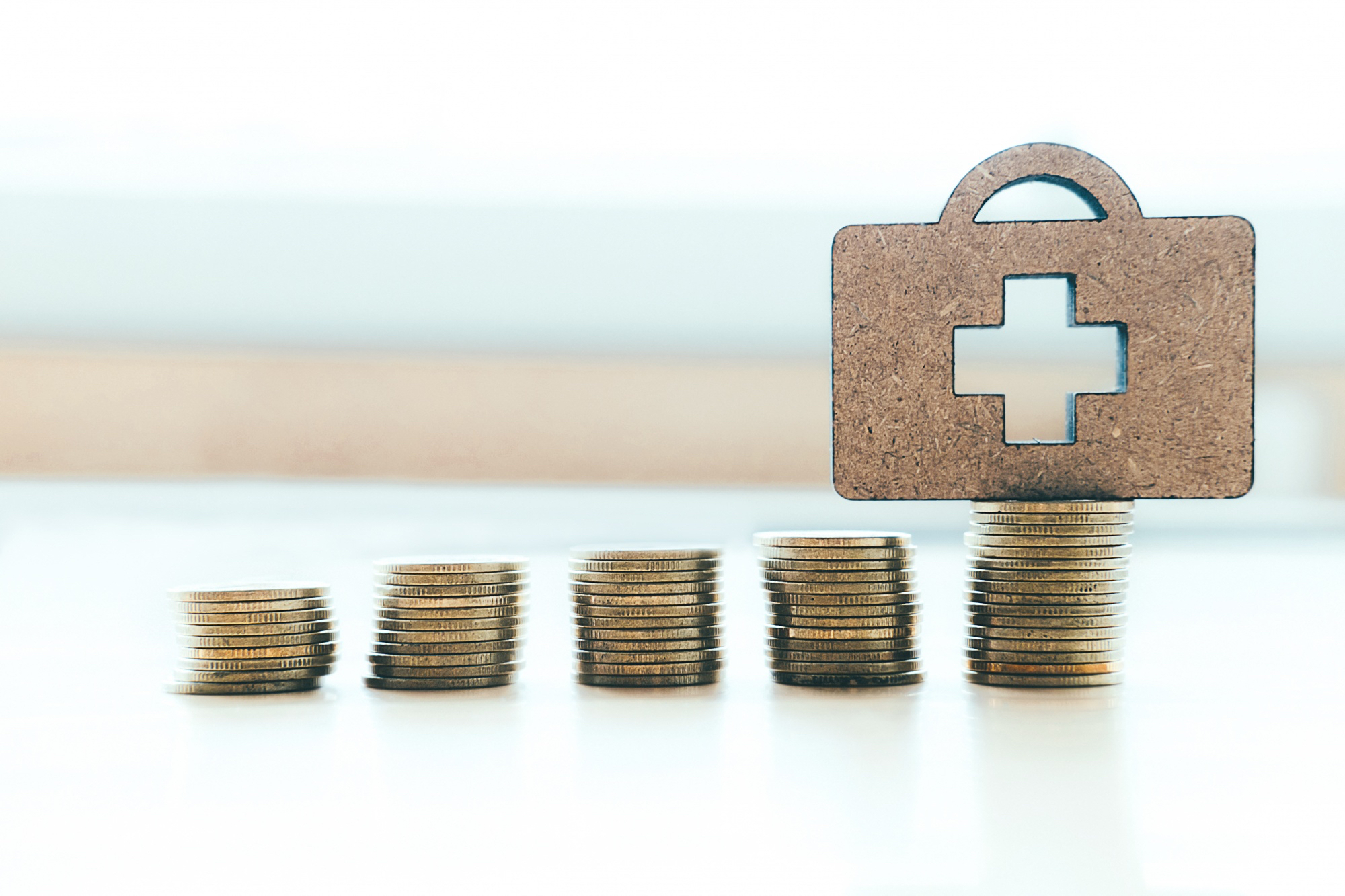 Stacks of coins in different amounts contributing to health care.